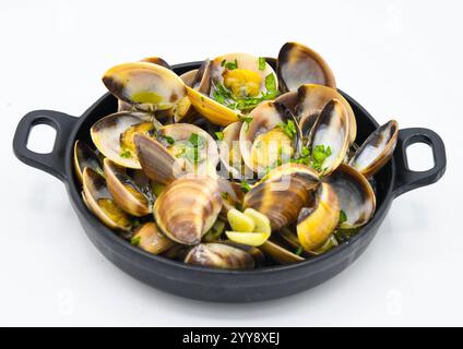 Vongole cotte in padella con prezzemolo su sfondo bianco Foto Stock
