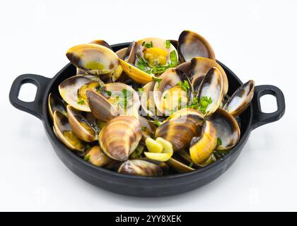 Vongole cotte in padella con prezzemolo su sfondo bianco Foto Stock