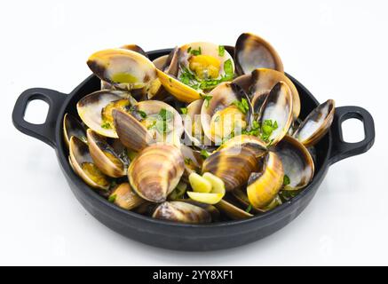 Vongole cotte in padella con prezzemolo su sfondo bianco Foto Stock