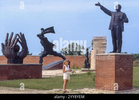 Ungheria, Budapest, turisti guardano la statua di Lenin nel Parco Memento o Szobor, un luogo in memoria della storia socialista. Foto Stock