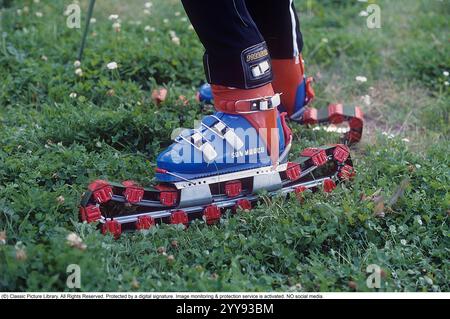 Slalom senza neve. Nel 1980 una nuova invenzione degli sci d'erba è in fase di sperimentazione, in estate. Gli sci sono costruiti con nastri rotanti e hanno funzionalità simili a quelle degli sci normali. Nella foto un uomo che prova gli sci rotolanti in estate su una collina ricoperta di erba. C'erano una manciata di produttori di sci d'erba negli anni '1980 Ecco una pagina web che racconta la storia dello sci d'erba: https://www.theskijournal.com/exclusive/grassholes/ rif. DV25 Foto Stock