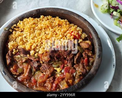 Agnello güveç o kuzu güveç con pilaf di riso preparato in una padella di ghisa Foto Stock