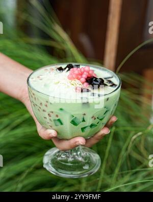 Un rinfrescante dessert halo-halo filippino servito in un calice di calice, con ghiaccio tritato, fagioli dolci, nata de coco, leche flan, jackfruit e eva Foto Stock