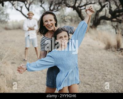 Madre e figlia in azione, con il padre dietro di loro Foto Stock