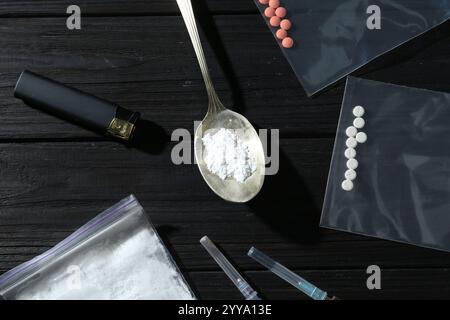 Composizione piatta con diversi farmaci su un tavolo di legno nero Foto Stock