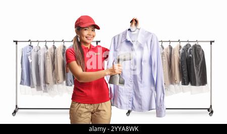 Il lavoratore asiatico della lavanderia stirava una camicia con un ferro a vapore a mano isolato su sfondo bianco Foto Stock