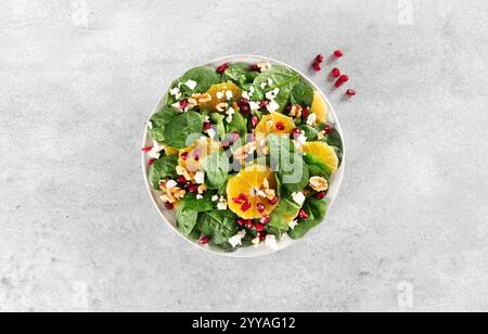 Insalata di Natale con arance, lattuga, melograno, noci e formaggio feta. Insalata verde vegetariana. Foto Stock