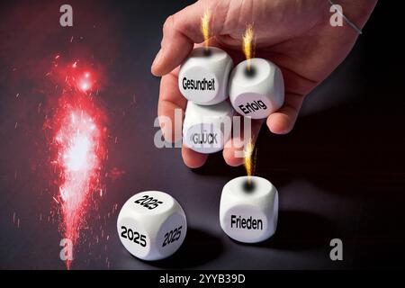 Baviera, Germania - 20 dicembre 2024: I fuochi d'artificio rossi illuminano il cielo mentre una mano tiene i cubi con i desideri per l'anno 2025. I cubi ardenti rappresentano la passione e la forza che accompagnano il nuovo anno. I desideri di Capodanno come la felicità, il successo e la pace sono rafforzati dalle scintille viventi e creano un'atmosfera festosa piena di speranza per il nuovo anno 2025. FOTOMONTAGGIO *** Rotes Feuerwerk leuchtet am Himmel, während eine hand Würfel mit Wünschen für das Jahr 2025 hält. Die brennenden Würfel stehen für die Leidenschaft und Kraft, Die das neue Jahr begleiten. Neujahrswünsche wie Glück, er Foto Stock