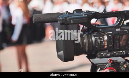 Videocamera professionale che filma i bambini durante la celebrazione del primo giorno scolastico, creando ricordi di questa importante pietra miliare Foto Stock