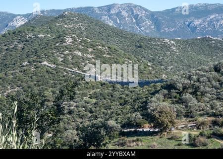 la fotografia aerea dell'acquedotto romano di patara cattura un antico muro di pietra serpeggiante attraverso un paesaggio verdeggiante. Foto Stock