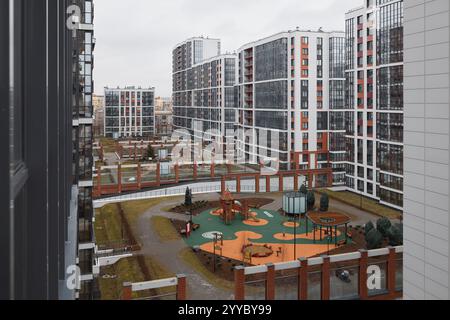 Un moderno complesso residenziale per famiglie con un parco giochi e servizi in un ambiente urbano Foto Stock