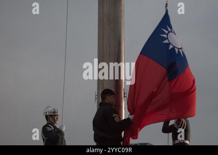 La Guardia d'Onore esegue la cerimonia di abbassamento della bandiera taiwanese in Piazza della libertà a Taiwan il 21 dicembre 2024. Foto Stock