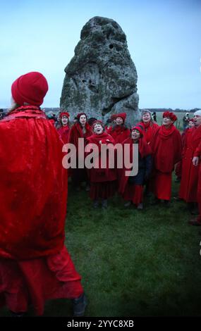 Salisbury, Inghilterra, Regno Unito. 21 dicembre 2024. Un coro canta il sole vicino alla pietra del tallone durante le celebrazioni del solstizio d'inverno. Il solstizio d'inverno 2024 segna sia il giorno più breve che la notte più lunga dell'anno. Il Solstizio segna anche l'inizio dello storico festival pagano, Yule. Stonehenge fu costruita per allinearsi al sole sui solstizi. (Credit Image: © Martin Pope/ZUMA Press Wire) SOLO PER USO EDITORIALE! Non per USO commerciale! Crediti: ZUMA Press, Inc./Alamy Live News Foto Stock