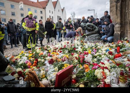 Nach dem gestrigen Anschlag auf den Magdeburger Weihnachtsmarkt legten am Samstag 21.12.2024 viele Menschen Blumen am Eingang der St.-Johannis-Kirche a Magdeburg nieder. Auf den Weihnachtsmarkt in der Innenstadt von Magdeburg ist am Freitagabend 20.12.2024 ein mutmasslicher Anschlag veruebt worden. Ein Auto War in Die Menschenmenge auf dem Weihnachtsmarkt gerast. I mindestini LAT Polizei fuhr der Taeter 400 metri di altezza dal Weihnachtsmarkt . Bislang starben fuenf Menschen bei dem Anschlag, darunter ein Kleinkind. Mehr als 200 wurden verletzt, viele davon schwer. Der mutmassliche Taeter ist ein Foto Stock