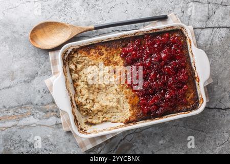 Piatto finlandese Maksalaatikko a base di riso, fegato tritato, burro, sciroppo, uova, cipolle servite con marmellata di mirtilli da primo piano nel piatto da forno sul tavolo. Hori Foto Stock