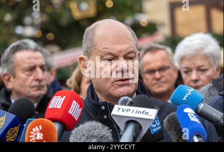 Nach dem gestrigen Anschlag auf den Magdeburger Weihnachtsmarkt besuchte am Samstag 21.12.2024 Bundeskanzler Olaf Scholz SPD den Ort des Attentats. Auf den Weihnachtsmarkt in der Innenstadt von Magdeburg ist am Freitagabend 20.12.2024 ein mutmasslicher Anschlag veruebt worden. Ein Auto War in Die Menschenmenge auf dem Weihnachtsmarkt gerast. I mindestini LAT Polizei fuhr der Taeter 400 metri di altezza dal Weihnachtsmarkt . Bislang starben fuenf Menschen bei dem Anschlag, darunter ein Kleinkind. Mehr als 200 wurden verletzt, viele davon schwer. Der mutmassliche Taeter ist ein seit 2006 in Deutschlan Foto Stock