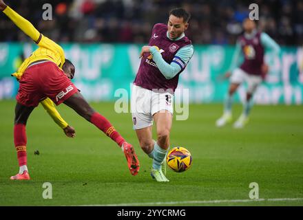 Pierre Dwomoh di Watford (a sinistra) e Josh Brownhill di Burnley si battono per il pallone durante lo Sky Bet Championship match a Turf Moor, Burnley. Data foto: Sabato 21 dicembre 2024. Foto Stock