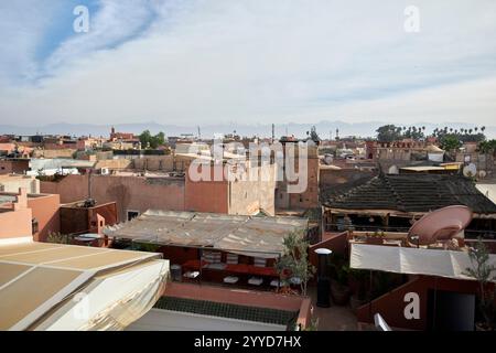 guardando sui tetti della medina di marrakech verso le montagne innevate dell'atlante marrakech, marocco Foto Stock