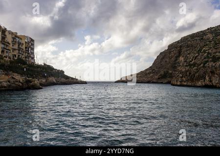 Vista panoramica sulla spiaggia con costa rocciosa e calme acque oceaniche sotto cieli nuvolosi Foto Stock
