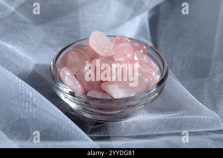 Diversi pezzi di quarzo rosa lucido su sfondo testurizzato. Vista dall'alto minima della fotografia STILL Life a colori Foto Stock