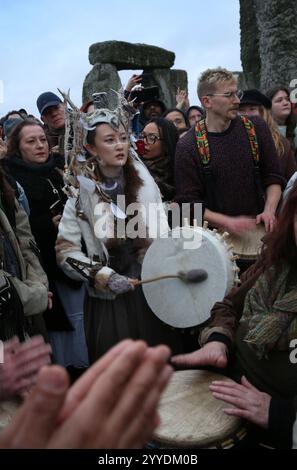 Salisbury, Inghilterra, Regno Unito. 21 dicembre 2024. Nel cerchio di pietre i visitatori suonano strumenti e alcuni indossano costumi pagani durante le celebrazioni del solstizio d'inverno. Il solstizio d'inverno 2024 segna sia il giorno più breve che la notte più lunga dell'anno. Il Solstizio segna anche l'inizio dello storico festival pagano, Yule. Stonehenge fu costruita per allinearsi al sole sui solstizi. (Credit Image: © Martin Pope/ZUMA Press Wire) SOLO PER USO EDITORIALE! Non per USO commerciale! Foto Stock