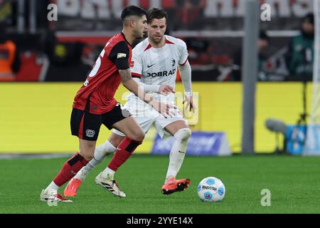 21.12.2024, BayArena, Leverkusen, GER, 1.FBL. Bayer 04 Leverkusen vs. SC Freiburg, im Bild Exequiel Palacios (Leverkusen #25), im Zweikampf gegen Lucas Höler/Hoeler (SC Freiburg #9), foto © nordphoto GmbH/Meuter DFL vietano qualsiasi uso di fotografie come sequenze di immagini e/o quasi video. Foto Stock