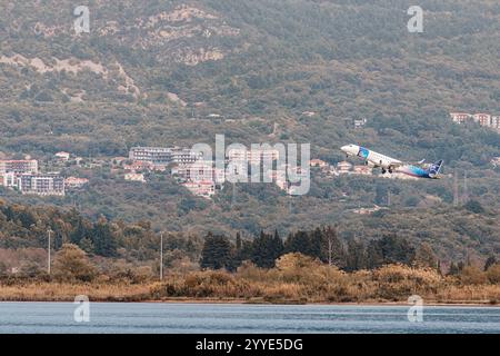 24 ottobre 2024, Tivat, Montenegro: Aereo passeggeri decollo su case e montagne vicino al mare Foto Stock