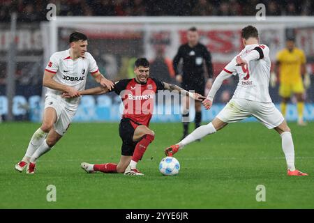 21.12.2024, BayArena, Leverkusen, GER, 1.FBL. Bayer 04 Leverkusen vs. SC Freiburg, im Bild Exequiel Palacios (Leverkusen #25), im Zweikampf gegen Maximilian Eggestein (SC Freiburg #8), Lucas Höler/Hoeler (SC Freiburg #9), foto © nordphoto GmbH/Meuter le normative DFL vietano qualsiasi uso di fotografie come sequenze di immagini e/o quasi-video. Foto Stock