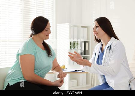 Nutrizionista che dà raccomandazioni alla donna in sovrappeso in ospedale Foto Stock