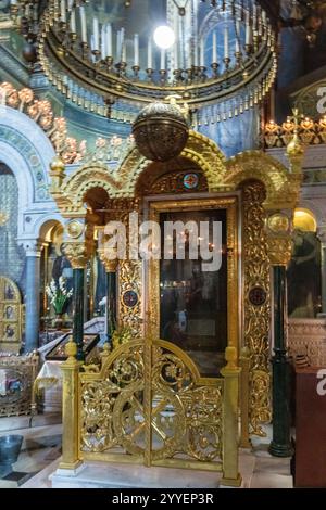 Una chiesa d'oro e d'argento con una porta d'oro e d'argento. La porta è chiusa. L'interno della chiesa è illuminato da candele Foto Stock