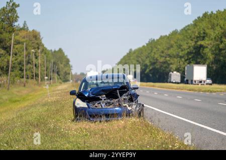 Una vecchia auto si è schiantata abbandonata sulla spalla della strada. Veicolo parcheggiato su strada danneggiato in caso di incidente stradale Foto Stock