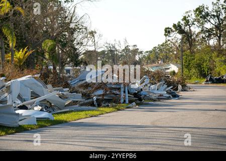 Mucchi di rifiuti sul lato della strada da case gravemente danneggiate dopo l'uragano nella zona residenziale delle case mobili della Florida. Conseguenze del disastro naturale Foto Stock