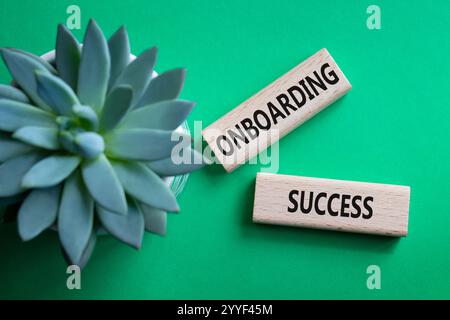 Simbolo onboarding riuscito. Concetto di integrazione di parole successo su blocchi di legno. Splendido sfondo verde con piante succulente. Affari e onboarding Foto Stock