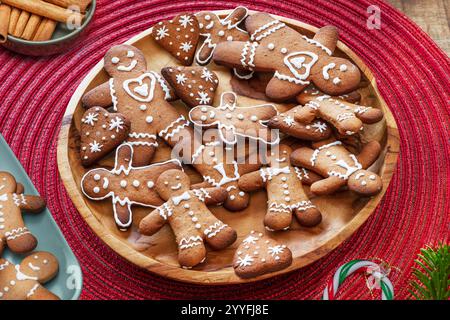 Uomini di pan di zenzero, biscotti di natale decorati con glassa reale su piatto blu, vista dall'alto. Foto Stock