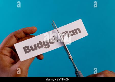 Tagliate le mani con il testo "budget Plan". Simboleggiando il taglio dei costi, la crisi finanziaria o la fine di un piano. Foto Stock