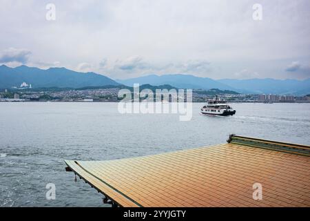 Miyajima, Giappone - 20 giugno 2024: I turisti prendono il traghetto JR Miyajima, il percorso tra Miyajimaguchi, Hatsukaichi, Hiroshima e Miyajima. Foto Stock