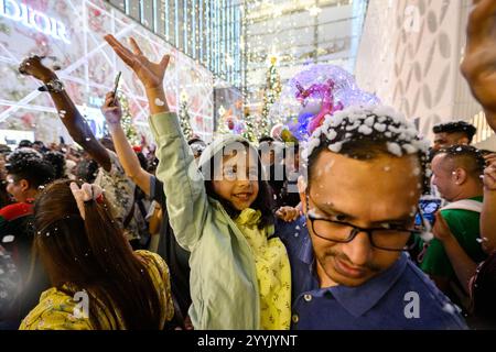 Kuala Lumpur, Malesia. 22 dicembre 2024. Le persone sono viste con fiocchi di neve artificiali in una strada a Kuala Lumpur, Malesia, 22 dicembre 2024. Crediti: Chong Voon Chung/Xinhua/Alamy Live News Foto Stock