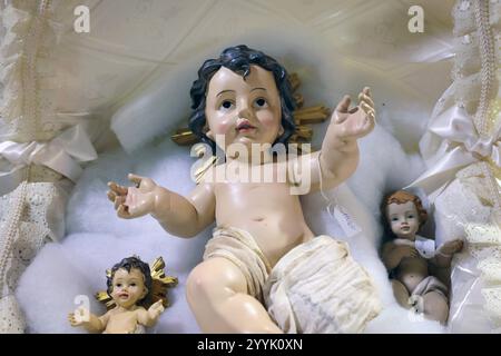 Napoli, Italia - 12 dicembre 2024: Statuetta in ceramica artigianale raffigurante Gesù bambino nella culla, in vendita a San Gregorio Armeno, il famoso Cristo Foto Stock