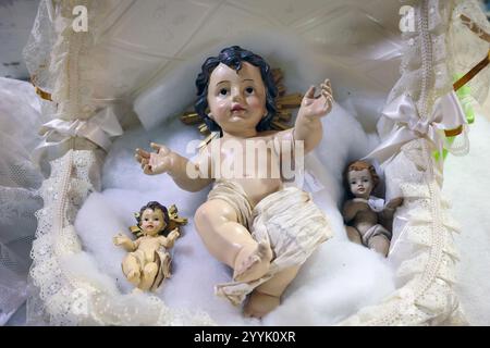 Napoli, Italia - 12 dicembre 2024: Statuetta in ceramica artigianale raffigurante Gesù bambino nella culla, in vendita a San Gregorio Armeno, il famoso Cristo Foto Stock