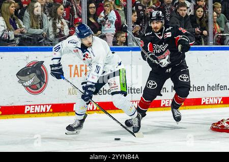 Germania. 22 dicembre 2024. Eishockey Penny-DEL 29.Spieltag Koelner Haie - Straubing Tigers AM 22.12.2024 in der Lanxess Arena a Koeln Michael Clarke ( Straubing ), Links - Maximilian Gloetzl ( Koeln ), rechts Gemaess den Vorgaben der DEL Deutsche Eishockey Liga ist die Publikation und Weiterverwertung der Aufnahmen in elektronischen Mediahren Endwaehmen in Spiehren Spiefnahmen. Foto: Revierfoto credito: ddp media GmbH/Alamy Live News Foto Stock