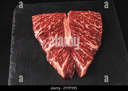 Bistecche di manzo a forma di cuore crudo marmorizzate con spezie su sfondo di pietra Copia il posto per il testo. Foto di alta qualità Foto Stock