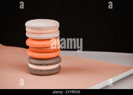 tavolozza pantone. Una collezione di macaron colorati disposti su uno sfondo rosa tenue. La foto mette in evidenza la delicatezza e la natura artistica di questo Foto Stock