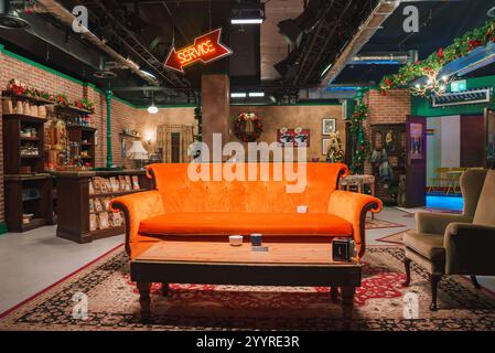 L'immagine mostra una replica dettagliata del caffè Central Perk di Friends, con l'iconico divano arancione, pareti in mattoni e decorazioni natalizie a Londo Foto Stock