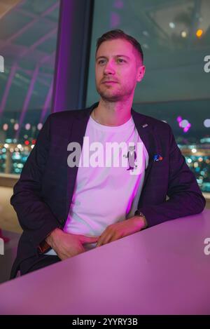 Uomo in un ambiente festoso di Londra con vista sulla città attraverso le finestre Foto Stock