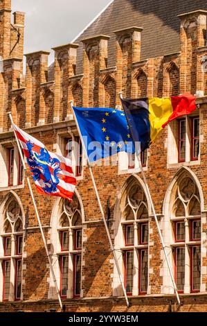 Bandiere tricolore di Bruges, Euro e Belgio in costruzione a Bruges, Fiandre occidentali, Belgio.pali di bandiera Foto Stock