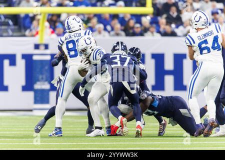 Indianapolis, Indiana, Stati Uniti. 22 dicembre 2024. Il running back degli Indianapolis Colts Jonathan Taylor (28) corre con la palla come la safety dei Tennessee Titans Amani Hooker (37) insegue durante la gara NFL al Lucas Oil Stadium di Indianapolis, Indiana. John Mersits/CSM/Alamy Live News Foto Stock