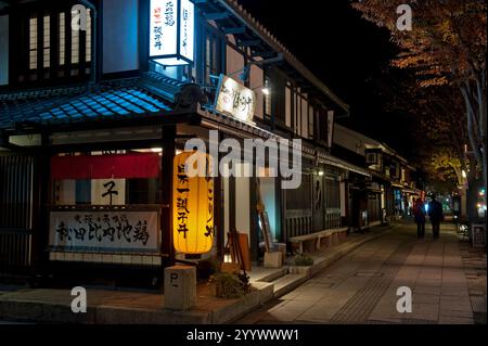 Le lanterne luminose di un ristorante illuminano la notte lungo la strada del castello di Yumekyobashi vicino al castello di Hikone a Hikone, Shiga, Giappone. Foto Stock