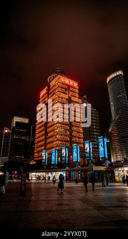 shanghai, Cina - 5 dicembre 2024 persone camminano di notte lungo il quartiere finanziario di Lujiazui. Foto Stock