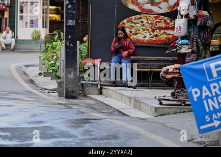 Una donna nepalese che controlla il suo telefono a Thamel, Kathmandu, Nepal. Foto Stock