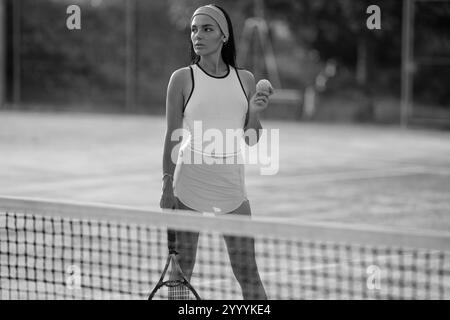 Donna in forma che gioca a tennis sul campo da tennis Foto Stock